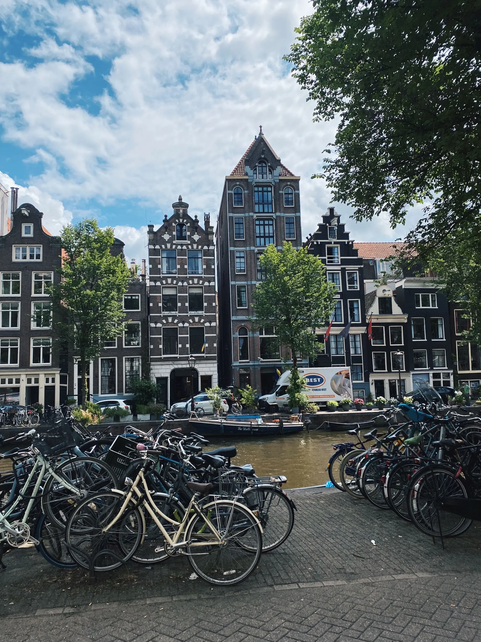 Fietsen aan een Amsterdamse gracht voor hoge gevels