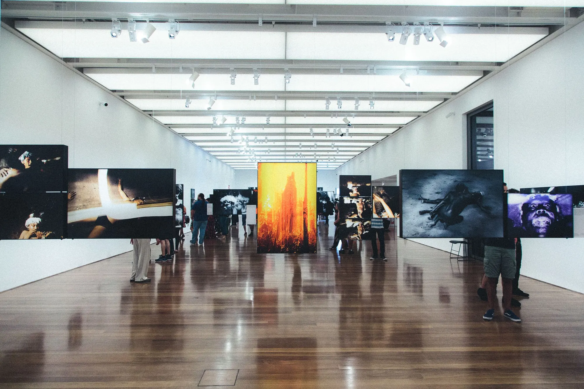 Museumzaal met houten vloer en werken aan wanden